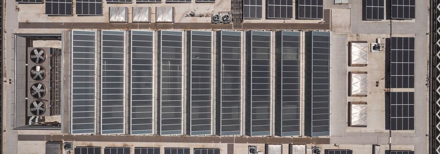 Aerial view of a warehouse roof fully covered in solar panels